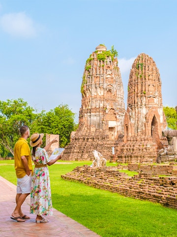 Couple exploring ancient temple ruins in Ayutthaya, Thailand.