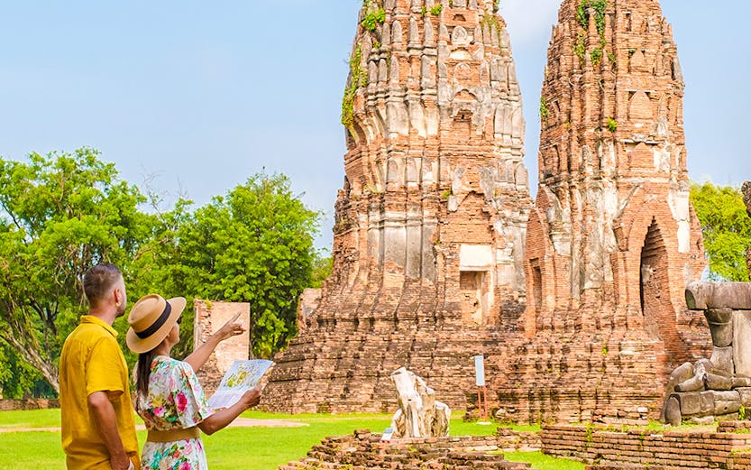Couple exploring ancient temple ruins in Ayutthaya, Thailand.