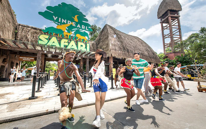 Zulu dancers performing at Vinpearl Safari entrance with visitors joining in.