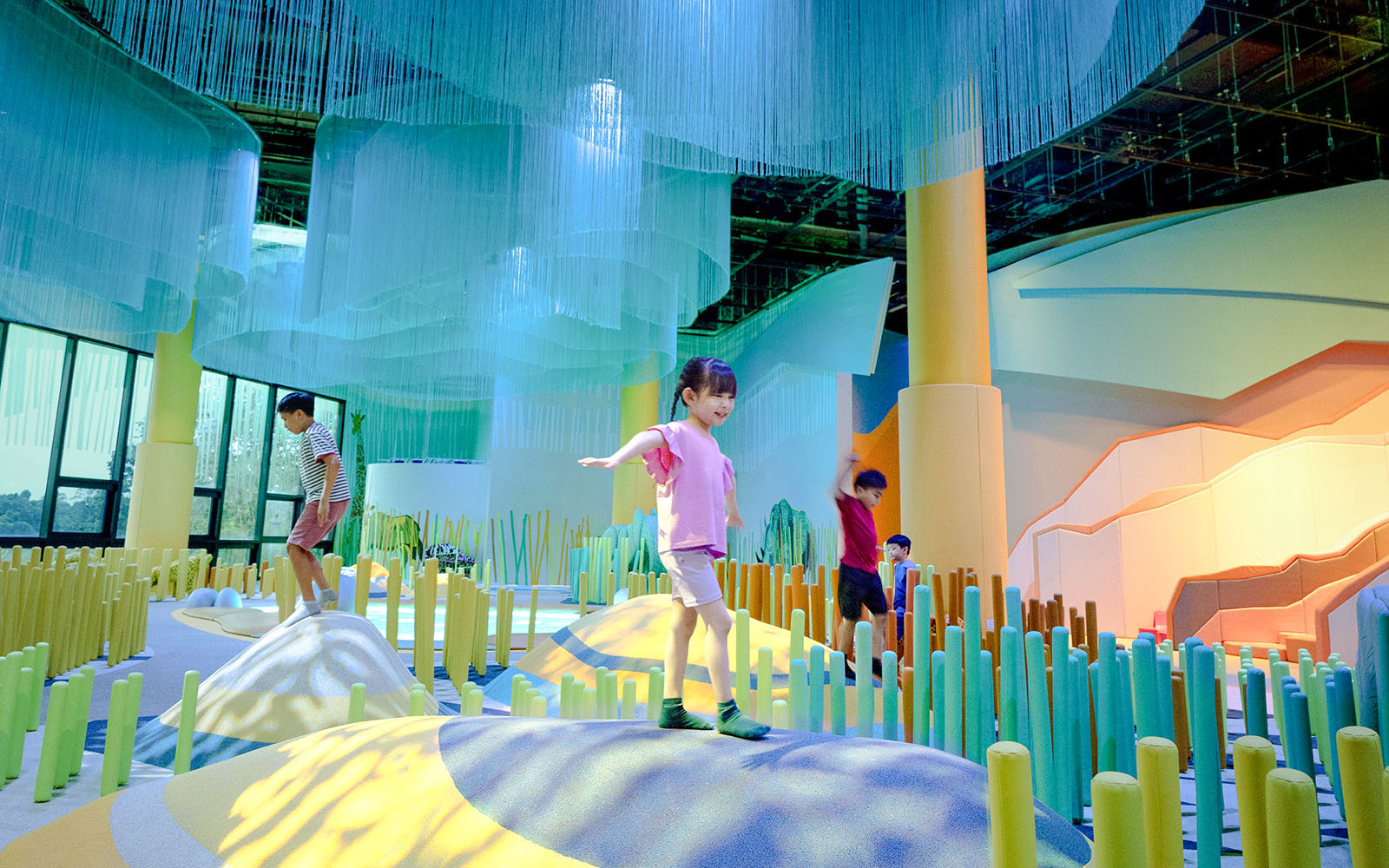 Children exploring colorful indoor play area at Grassland Camo Curiosity Cove.