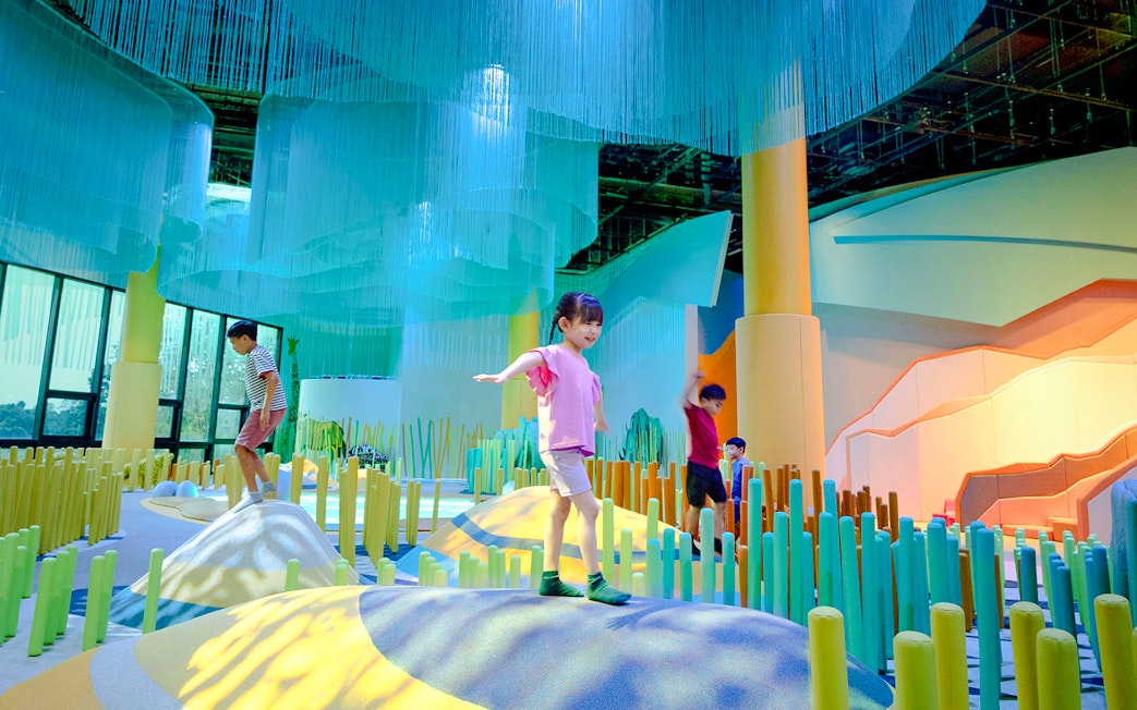 Children exploring colorful indoor play area at Grassland Camo Curiosity Cove.