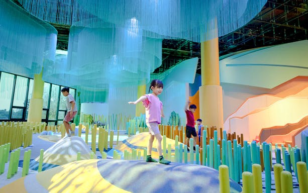 Children exploring colorful indoor play area at Grassland Camo Curiosity Cove.