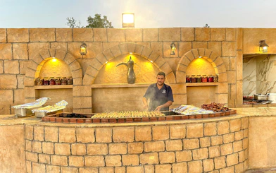 Grill chef preparing skewers at a desert safari barbecue station.