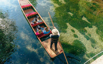 Punting on the Avon River in Christchurch with passengers enjoying the ride.