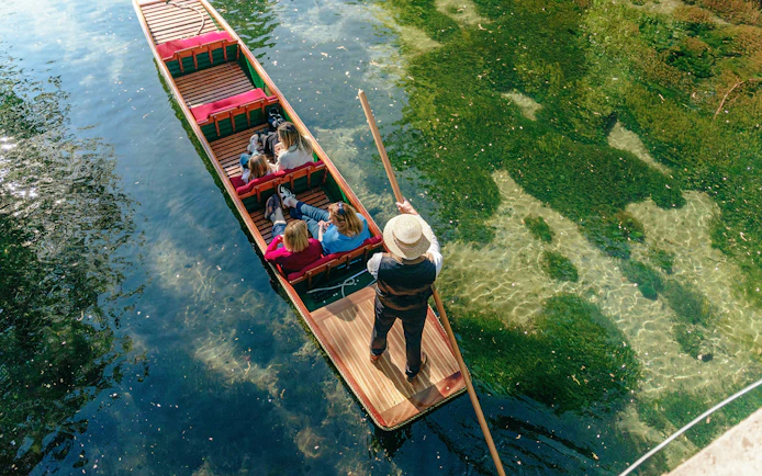 Punting on the Avon River in Christchurch with passengers enjoying the ride.