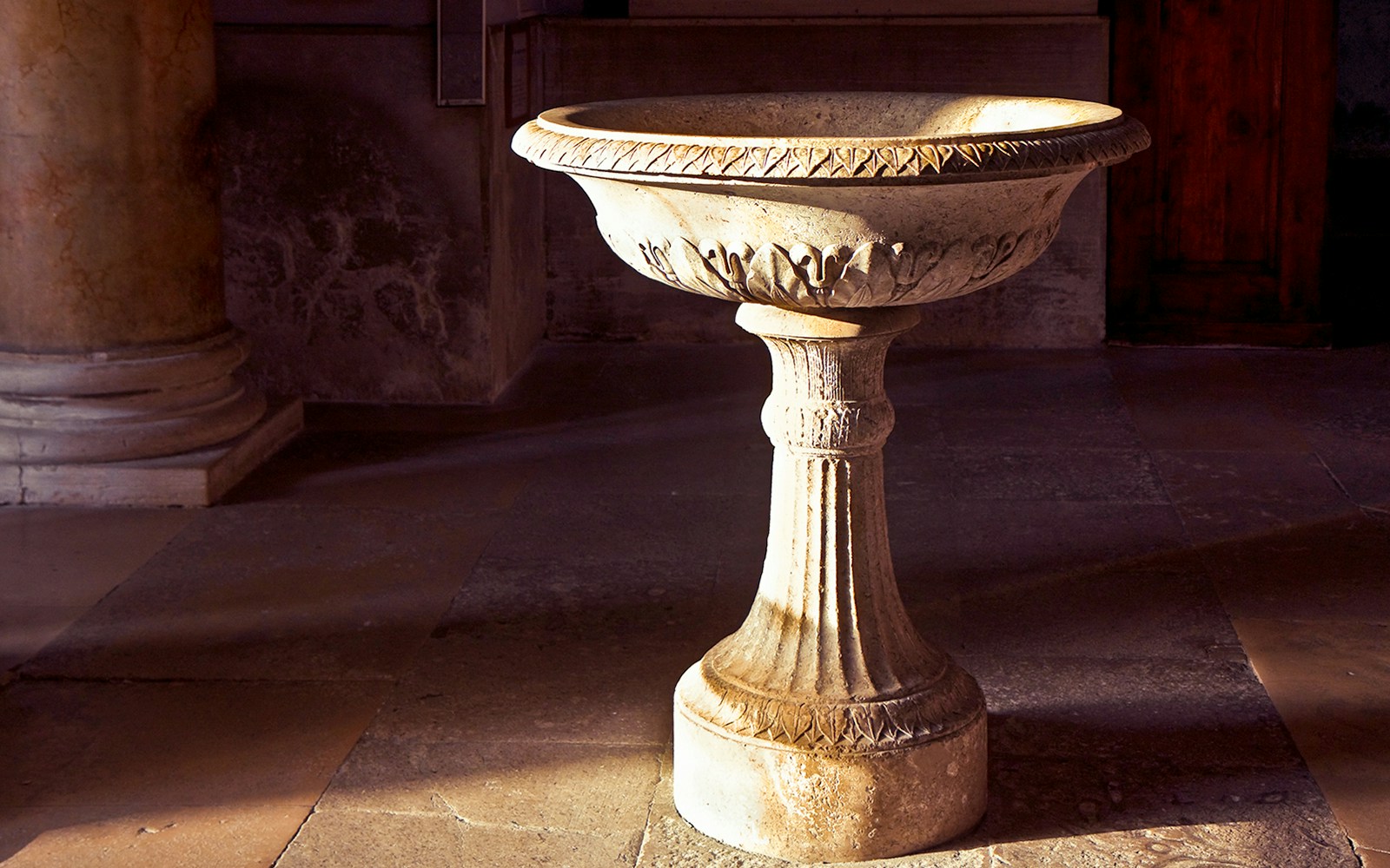 Baptismal font from ancient Christian period in Naples, Italy, with intricate carvings.