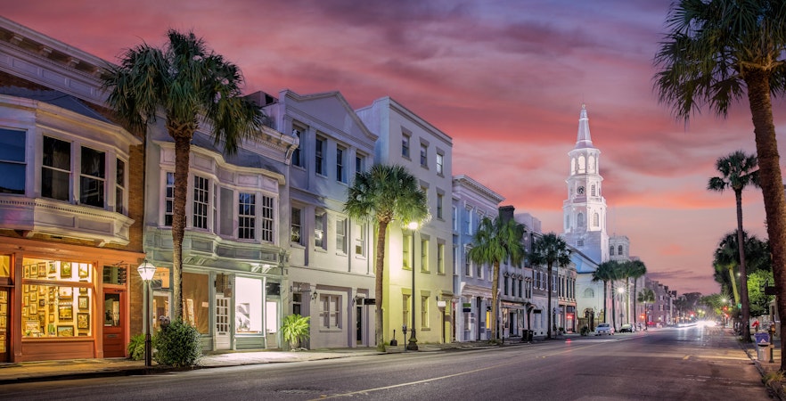 Downtown Charleston South Carolina street with historic buildings and sunset sky.