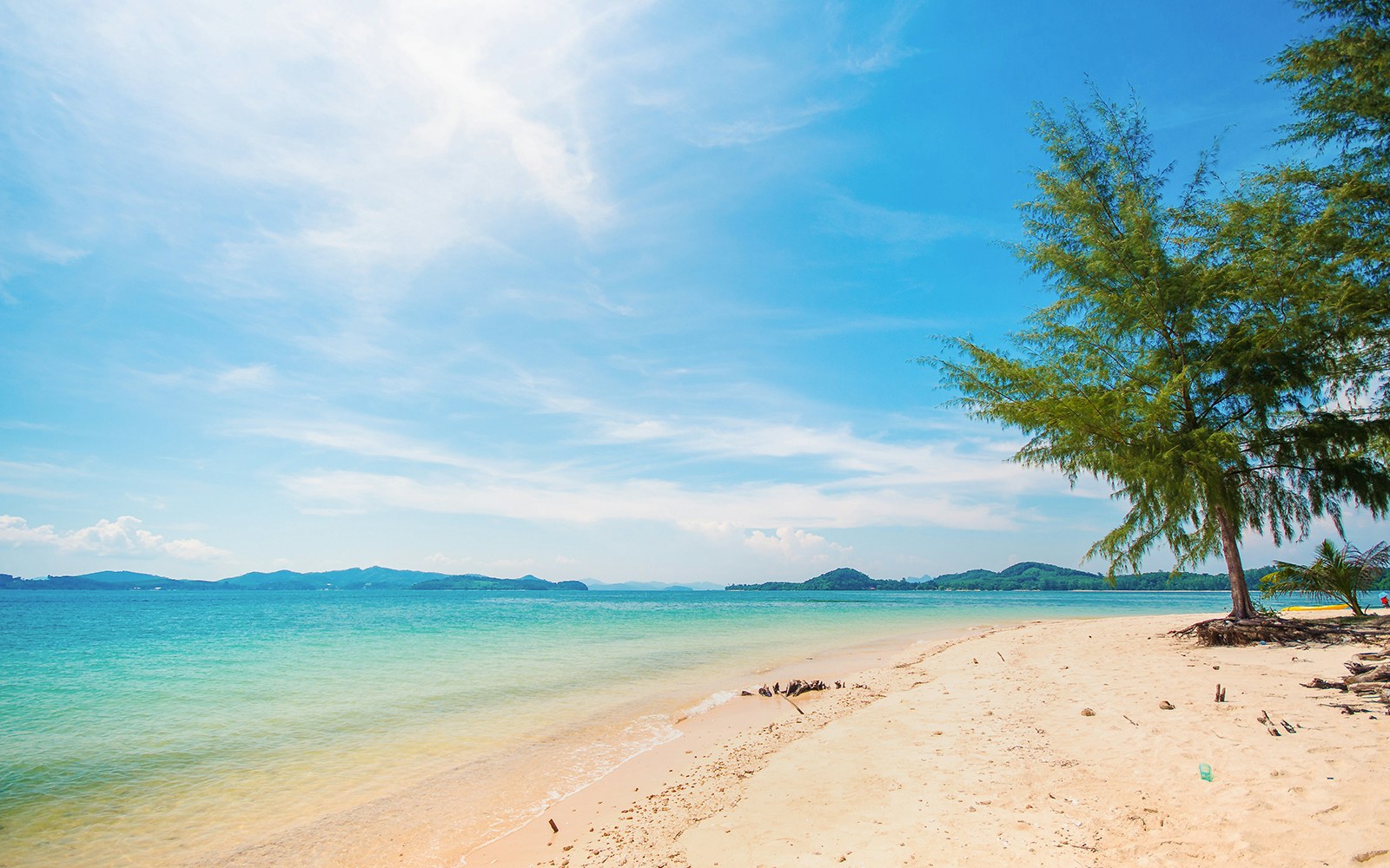 Naka Noi Beach shoreline with clear water and distant hills, ideal for swimming.