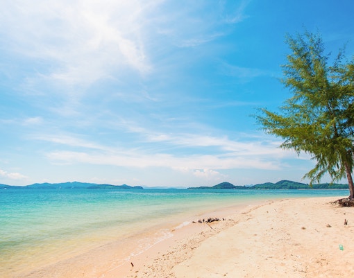 Naka Noi Beach shoreline with clear water and distant hills, ideal for swimming.