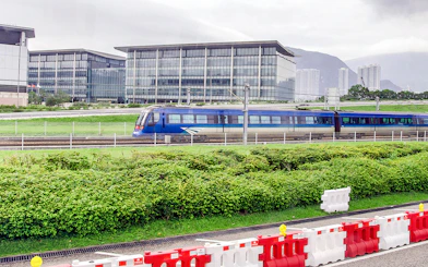 Hong Kong Airport Express train passing modern buildings.