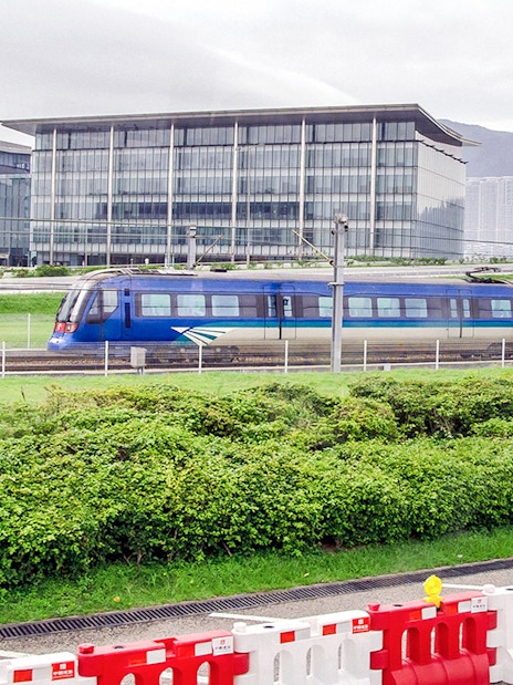 Hong Kong Airport Express train passing modern buildings.