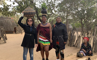 Tourists and locals in traditional attire at a cultural village near Durban.