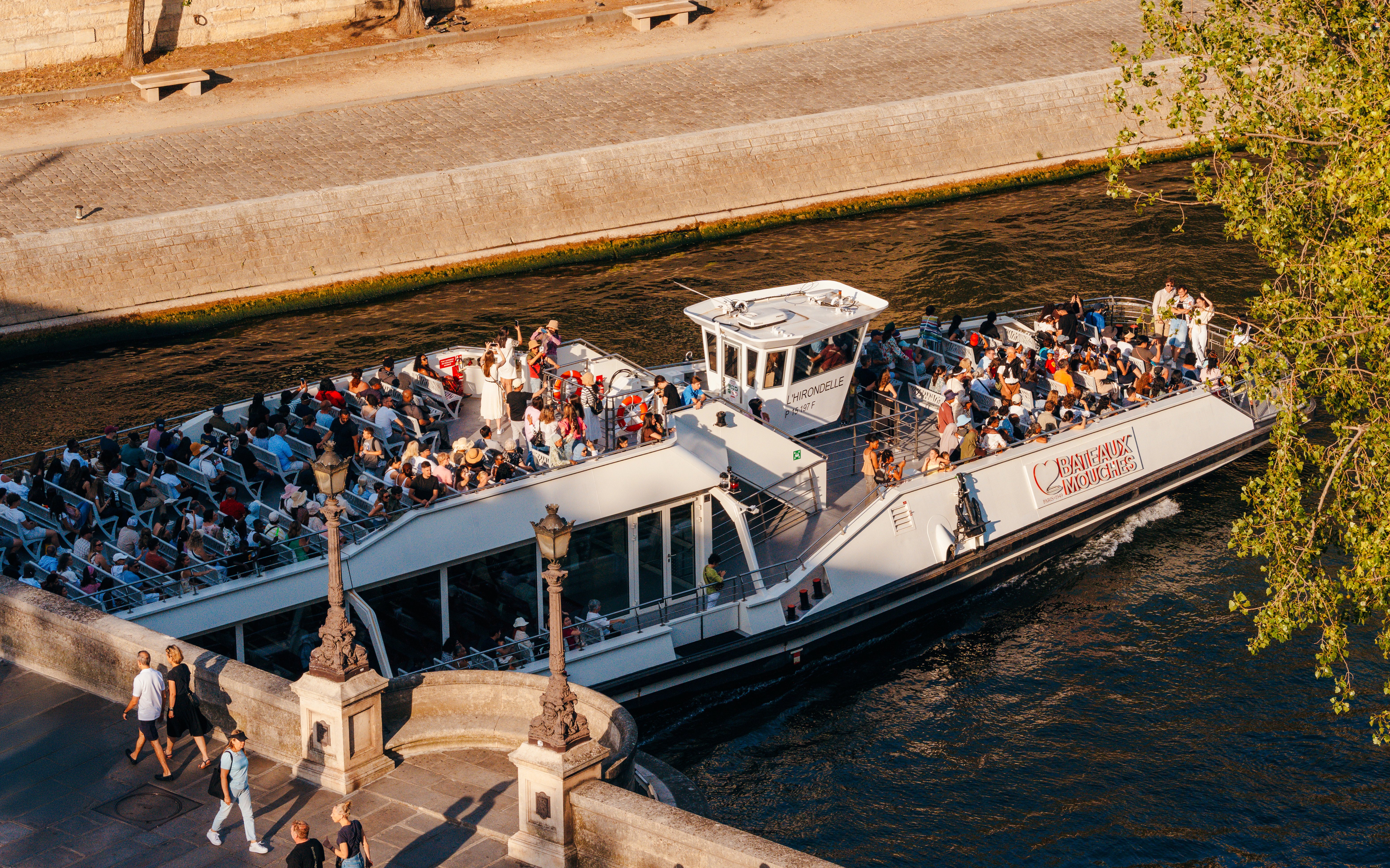 Seine River cruise boat with tourists enjoying an evening ride in Paris.