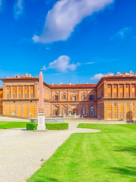 Pitti Palace facade with obelisk and green lawns, Florence, Italy.