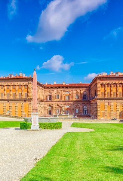 Pitti Palace facade with obelisk and green lawns, Florence, Italy.