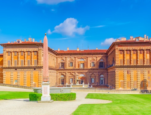 Pitti Palace facade with obelisk and green lawns, Florence, Italy.