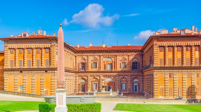Pitti Palace facade with obelisk and green lawns, Florence, Italy.