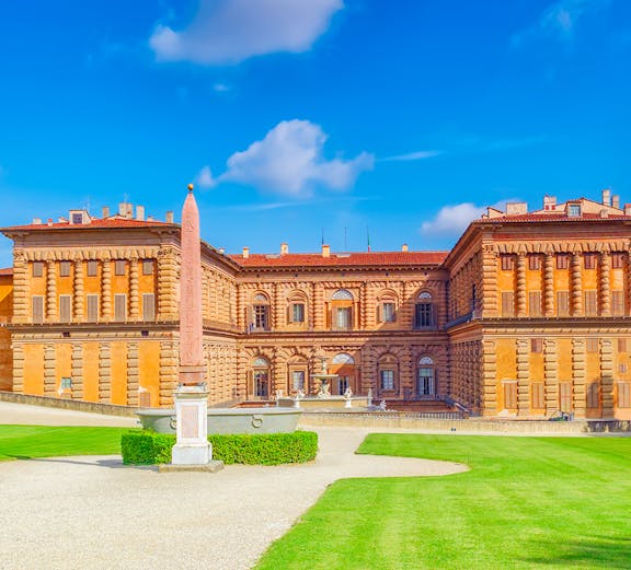 Pitti Palace facade with obelisk and green lawns, Florence, Italy.