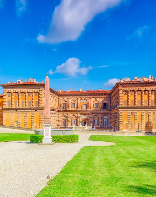 Pitti Palace facade with obelisk and green lawns, Florence, Italy.