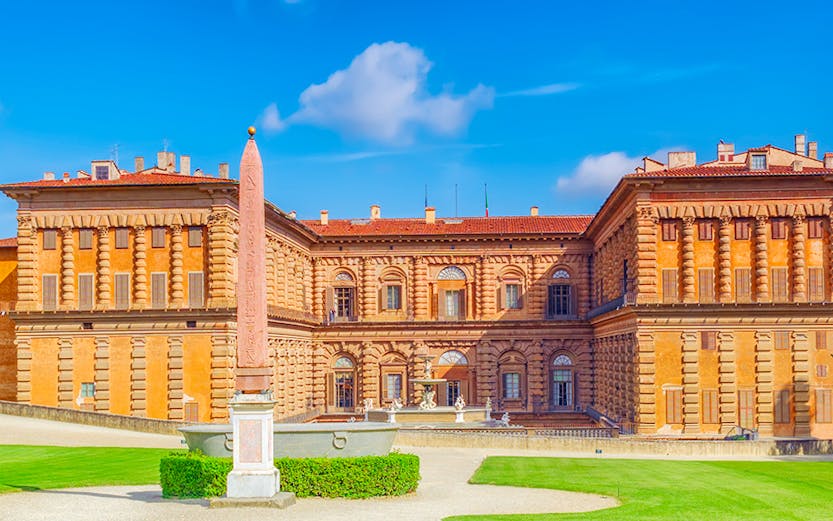 Pitti Palace facade with obelisk and green lawns, Florence, Italy.