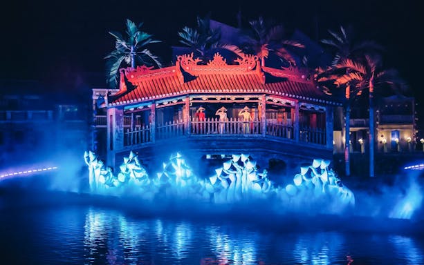 Hoi An Memories Show with performers on a lit stage over water, featuring traditional architecture.