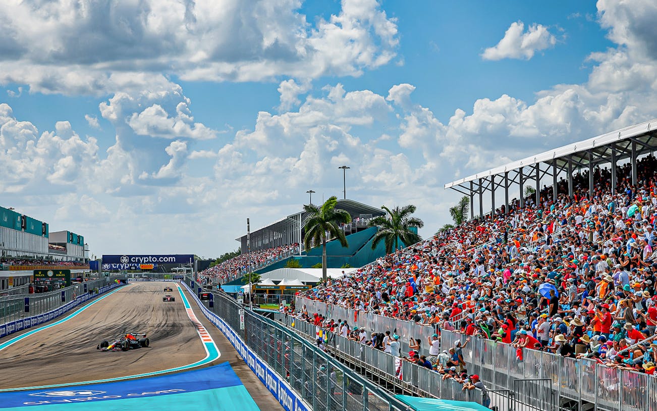 Formula 1 cars racing at Miami Grand Prix 2023 with packed grandstands.