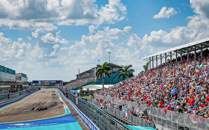 Formula 1 cars racing at Miami Grand Prix 2023 with packed grandstands.