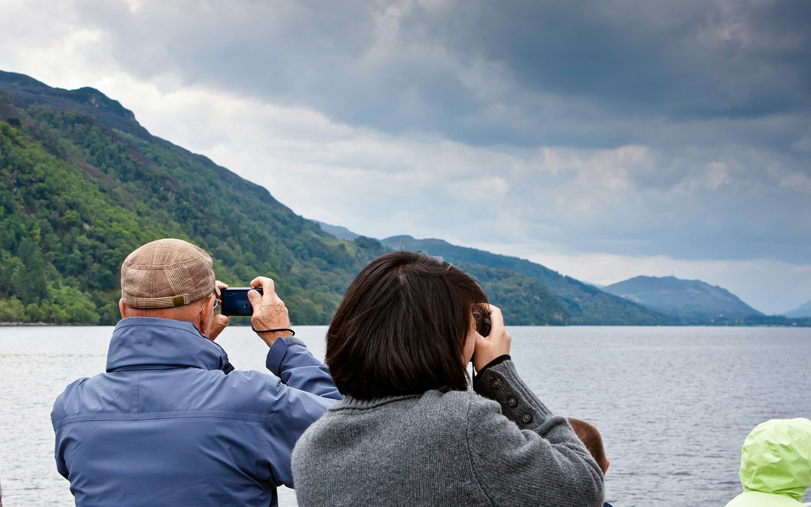 Tourists photographing Loch Ness from a high-speed cruise boat.