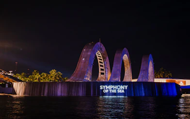 Exterior view of Symphony of the Sea with illuminated arches at night.