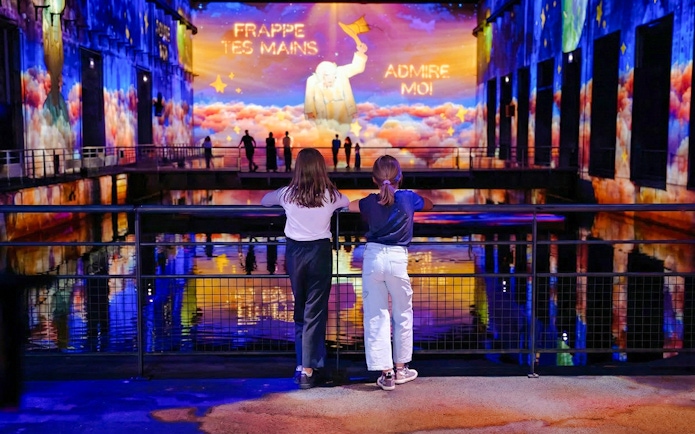 Children watching "The Little Prince" light show at Bassins des Lumières, Bordeaux.