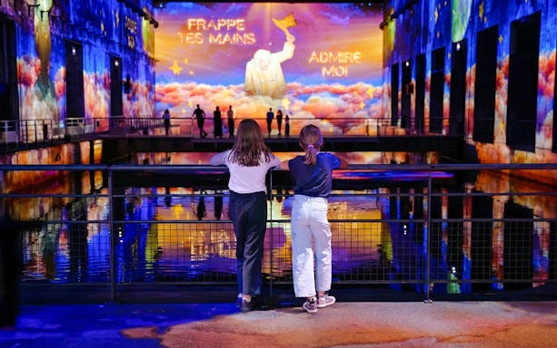 Children watching "The Little Prince" light show at Bassins des Lumières, Bordeaux.