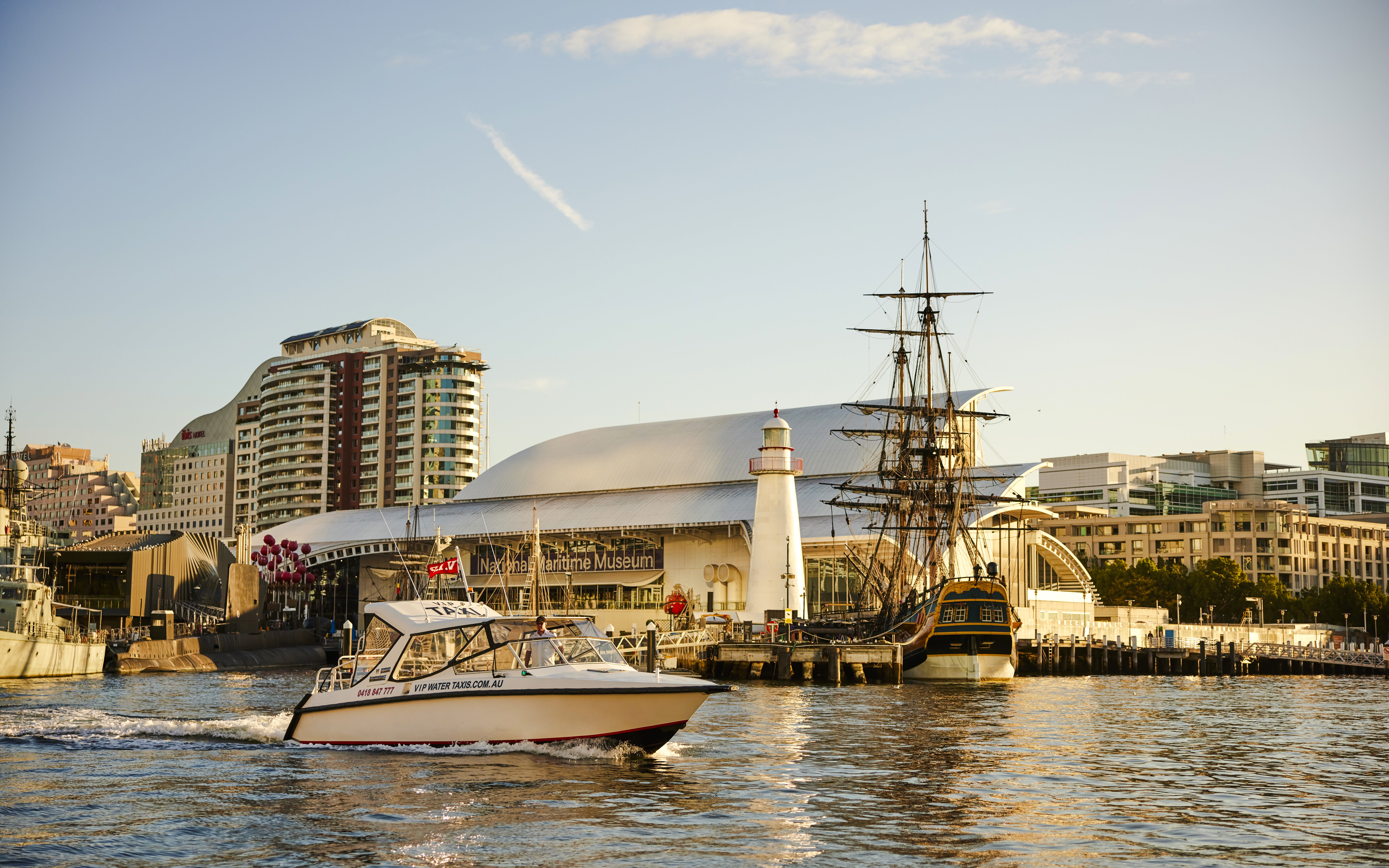 Sydney Harbour with boats near the Maritime Museum during sunset.