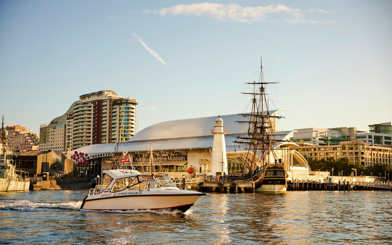 Sydney Harbour with boats near the Maritime Museum during sunset.