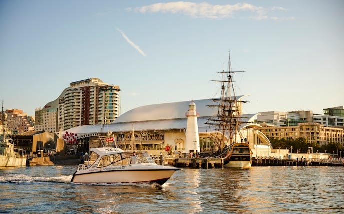 Sydney Harbour with boats near the Maritime Museum during sunset.