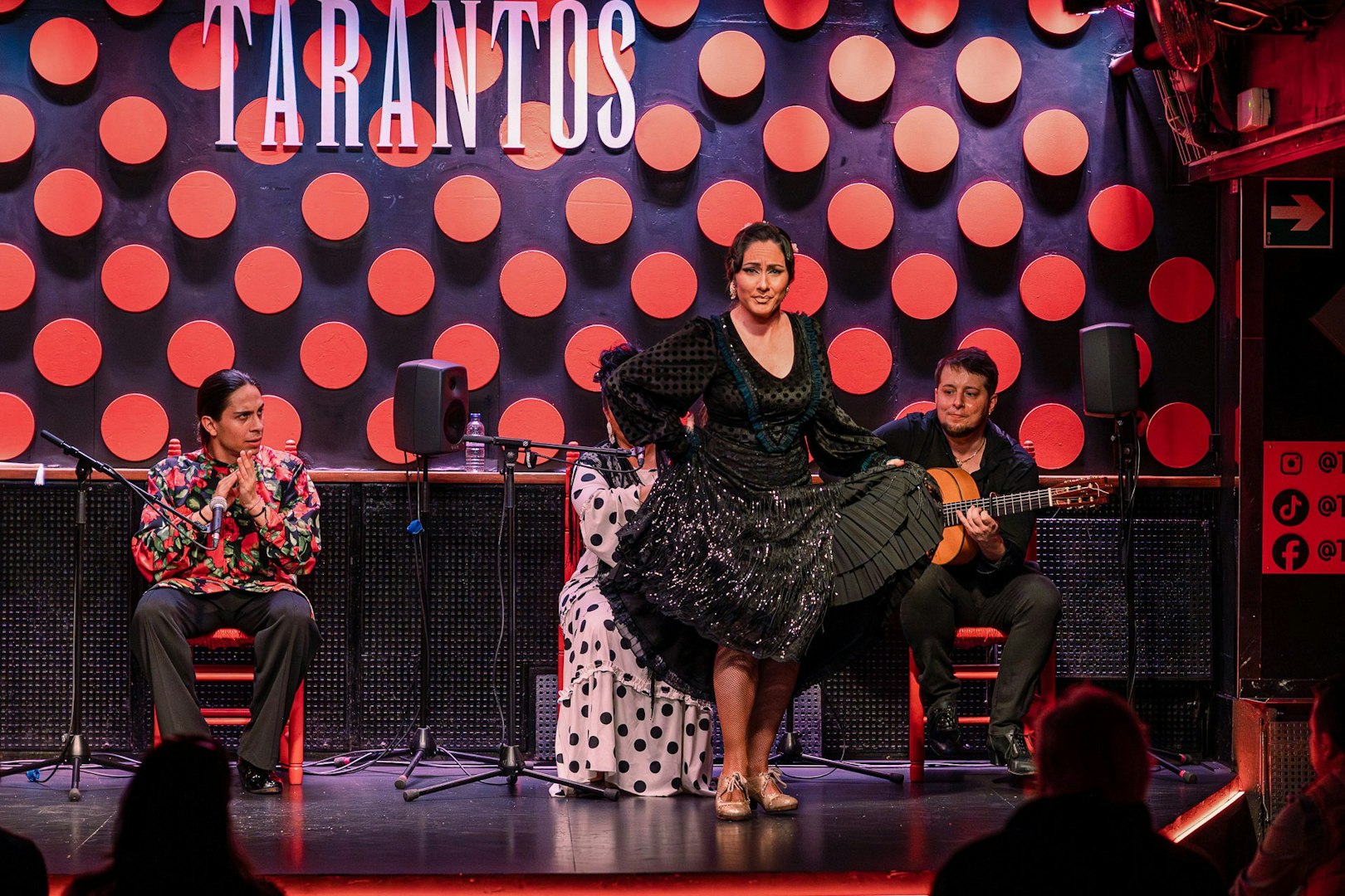 Flamenco dancer performing at Los Tarantos with musicians in Barcelona.