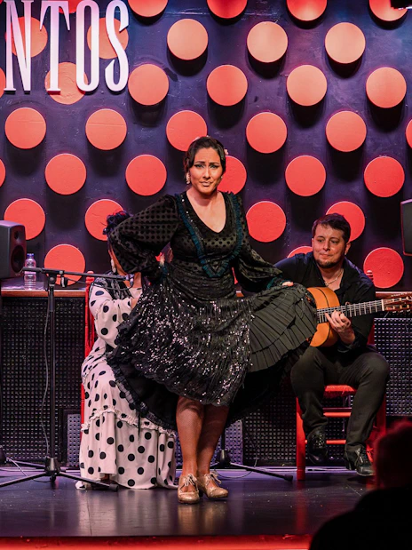 Flamenco dancer performing at Los Tarantos with musicians in Barcelona.