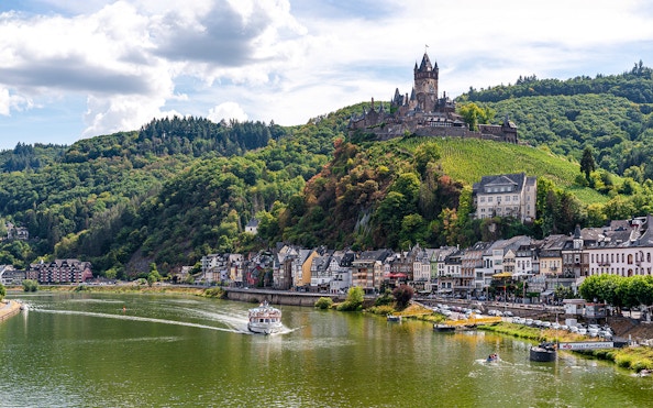 Cochem Castle overlooking the Moselle River with a cruise boat, seen from 1-Hour Panorama Cruise.