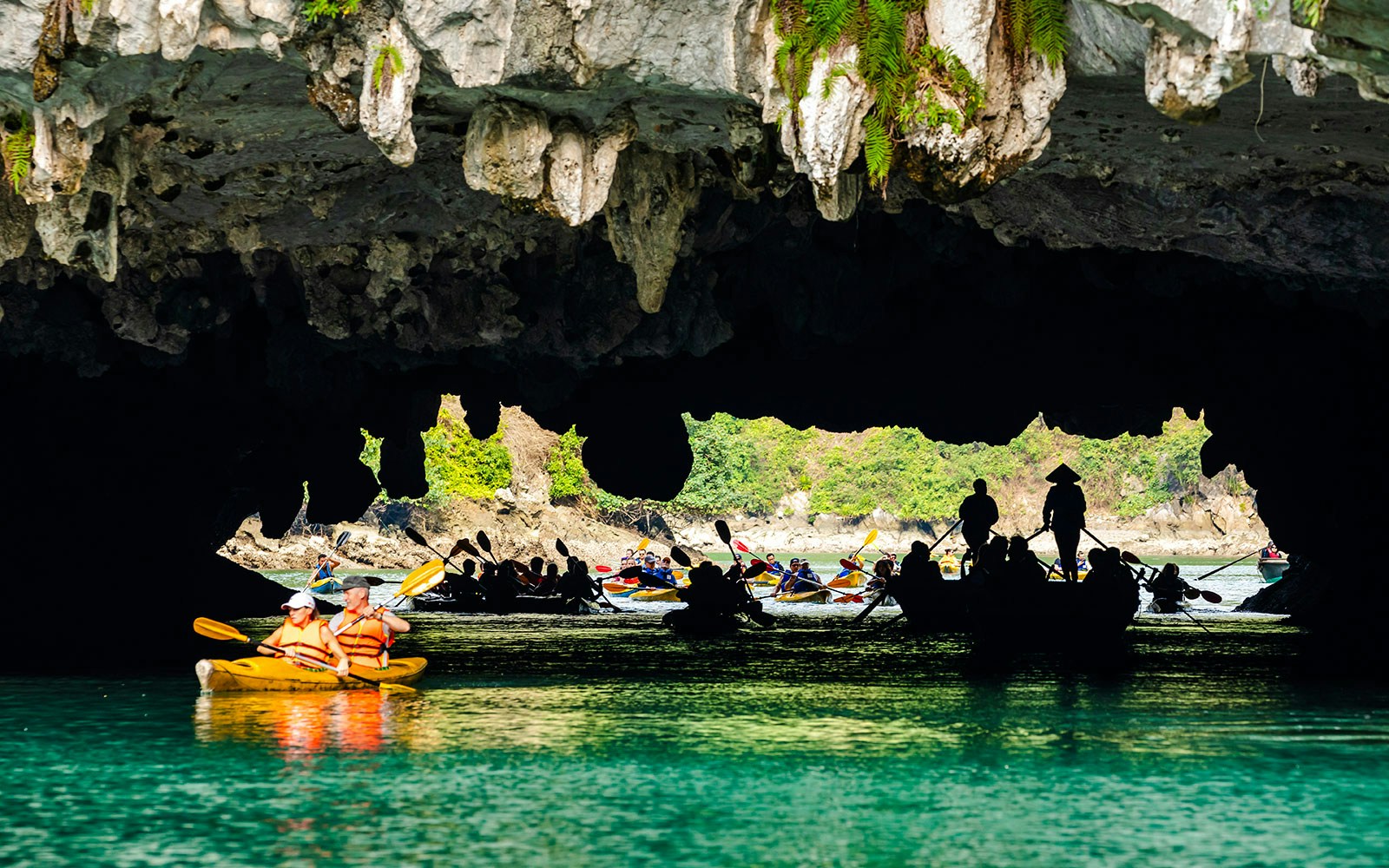 Kayakers exploring Luon Cave in Halong Bay, Vietnam.