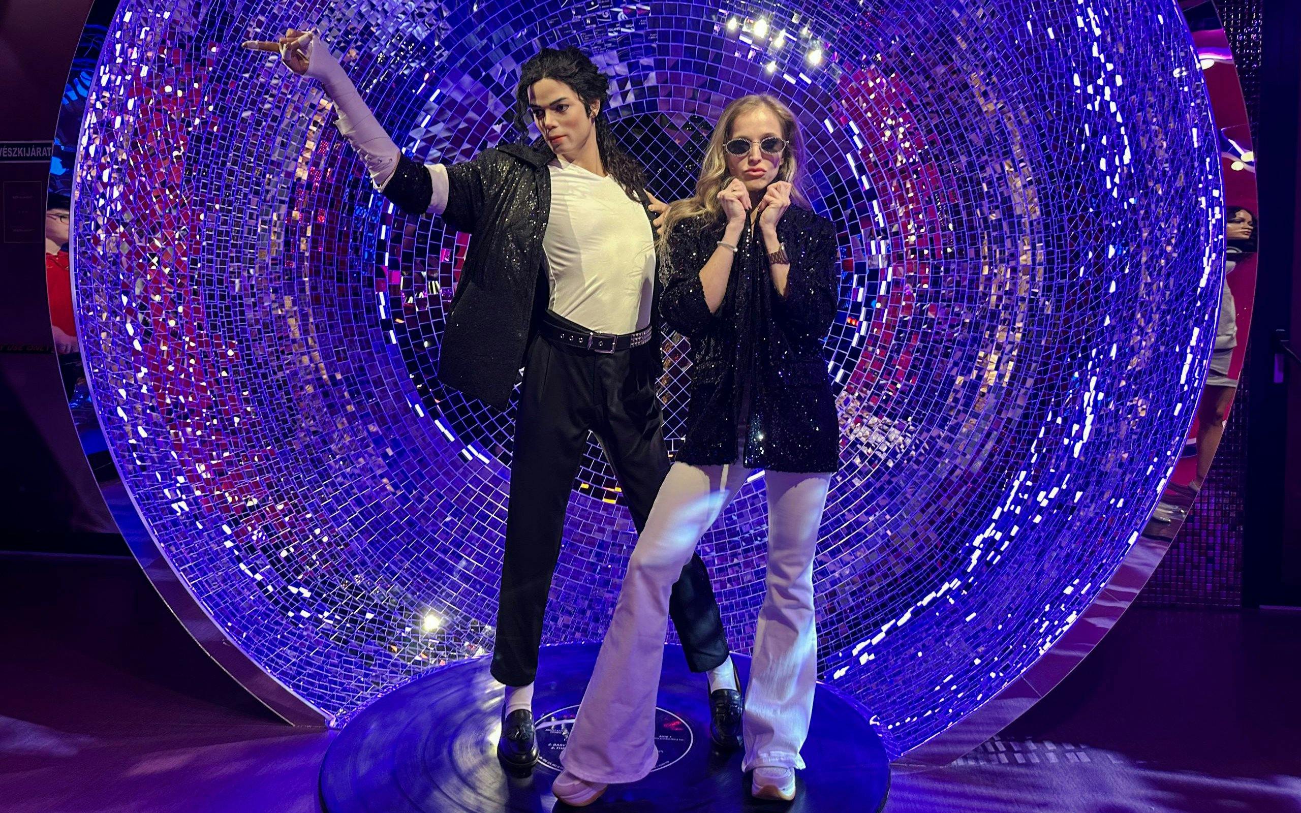 Wax figures at Madame Tussauds Budapest with a disco-themed backdrop.
