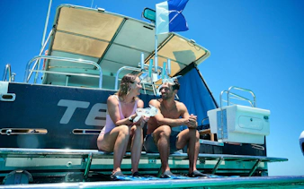 Couple sitting on boat deck preparing for Rottnest Island snorkel cruise.