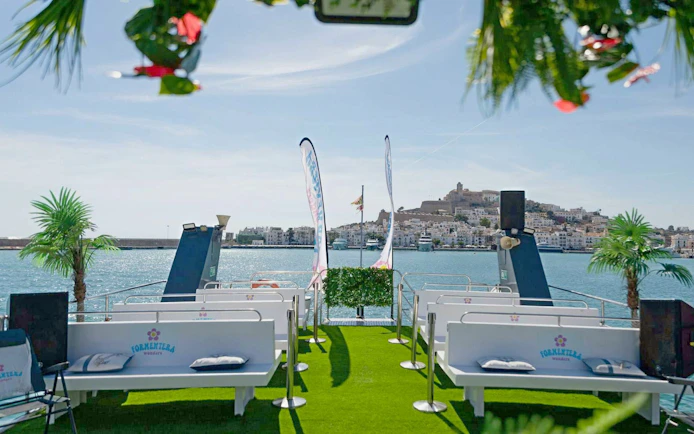 Cruise boat deck with seating, view of Ibiza town during Ibiza to Formentera cruise.
