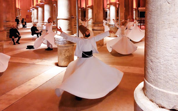 Whirling Dervishes performing in a historic hall in Istanbul.