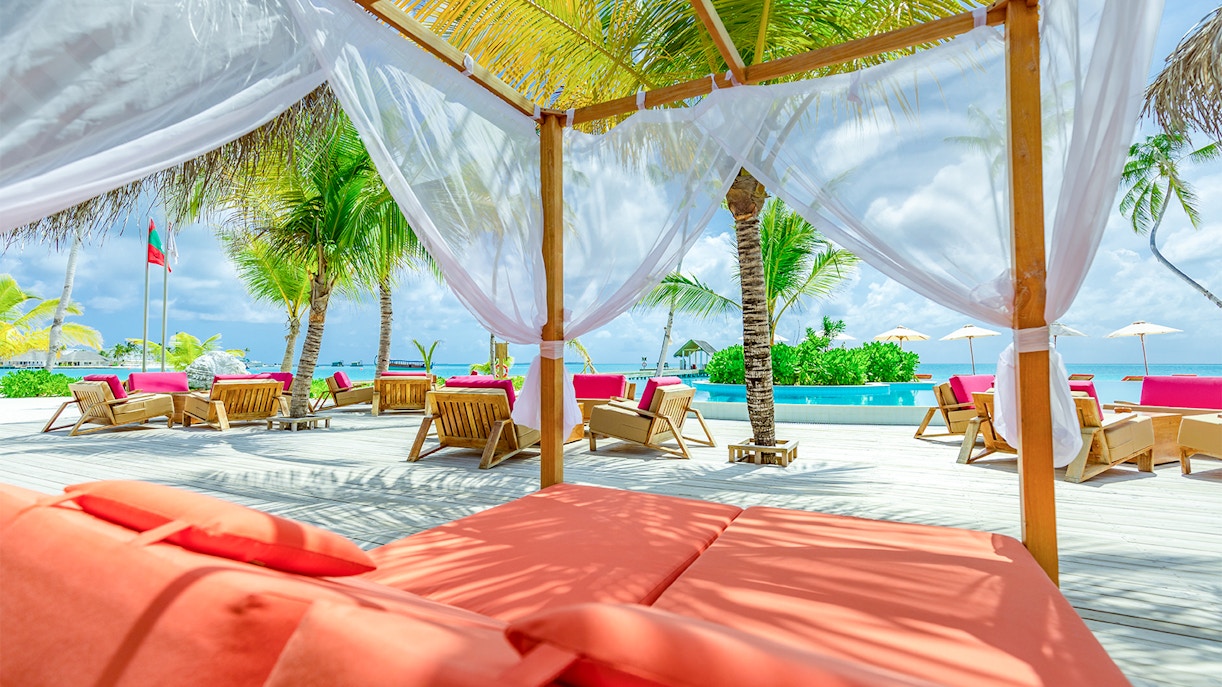 Poolside cabana with lounge chairs and palm trees at Yas Waterworld Abu Dhabi.