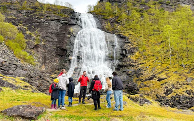 Group of tourists at Fossen Bratte waterfall in Eikedalen, Norway.
