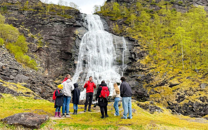 Group of tourists at Fossen Bratte waterfall in Eikedalen, Norway.