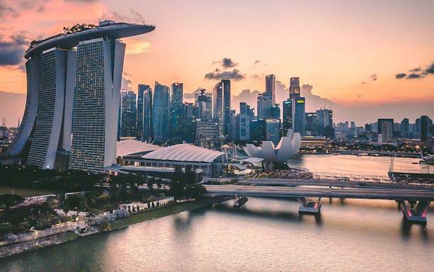 Singapore skyline at sunset with Marina Bay Sands and ArtScience Museum.