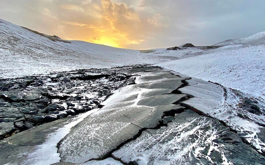 Volcanic landscape with snow-covered lava field at sunset, Reykjanes Peninsula, Iceland.