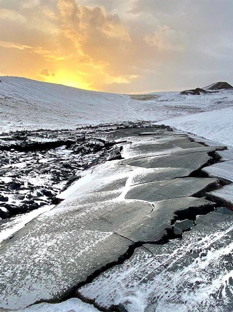 Volcanic landscape with snow-covered lava field at sunset, Reykjanes Peninsula, Iceland.