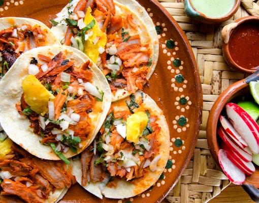 Traditional tacos al pastor with pineapple and cilantro in Mexico