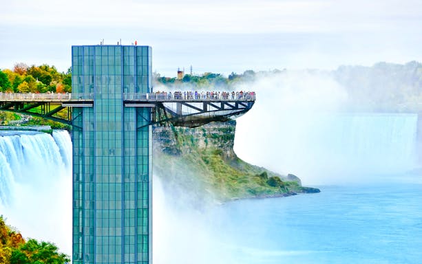 Prospect Point observation deck overlooking Niagara Falls, USA, with mist and river below.